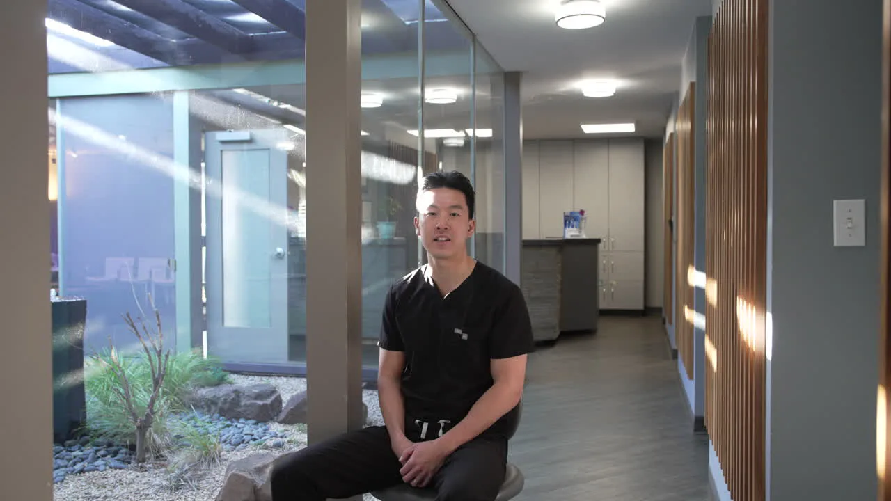Dr. Christopher B. Wong seated beside the office's garden courtyard